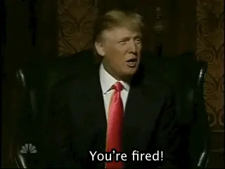 Donald Trump in a suit and red tie sitting in a dark room, saying 'You're fired!'