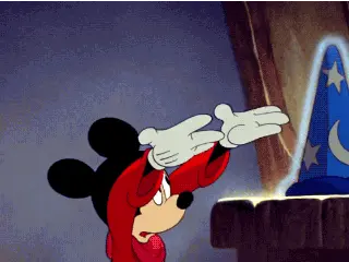 Mickey Mouse in a red robe reaching his white-gloved hands towards a glowing blue wizard hat with moon and star patterns.