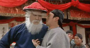 Stephen Chow in a period costume looking at someone and saying 'I want it all' in Chinese subtitles.